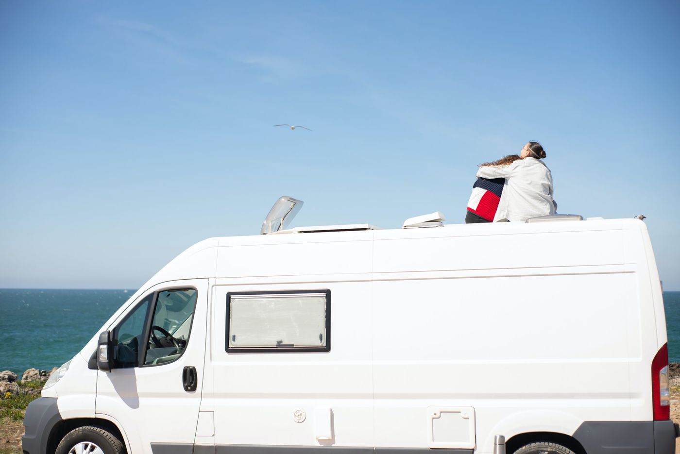 Furgoneta camper estacionada en un paisaje costero, lista para la aventura y el descanso.