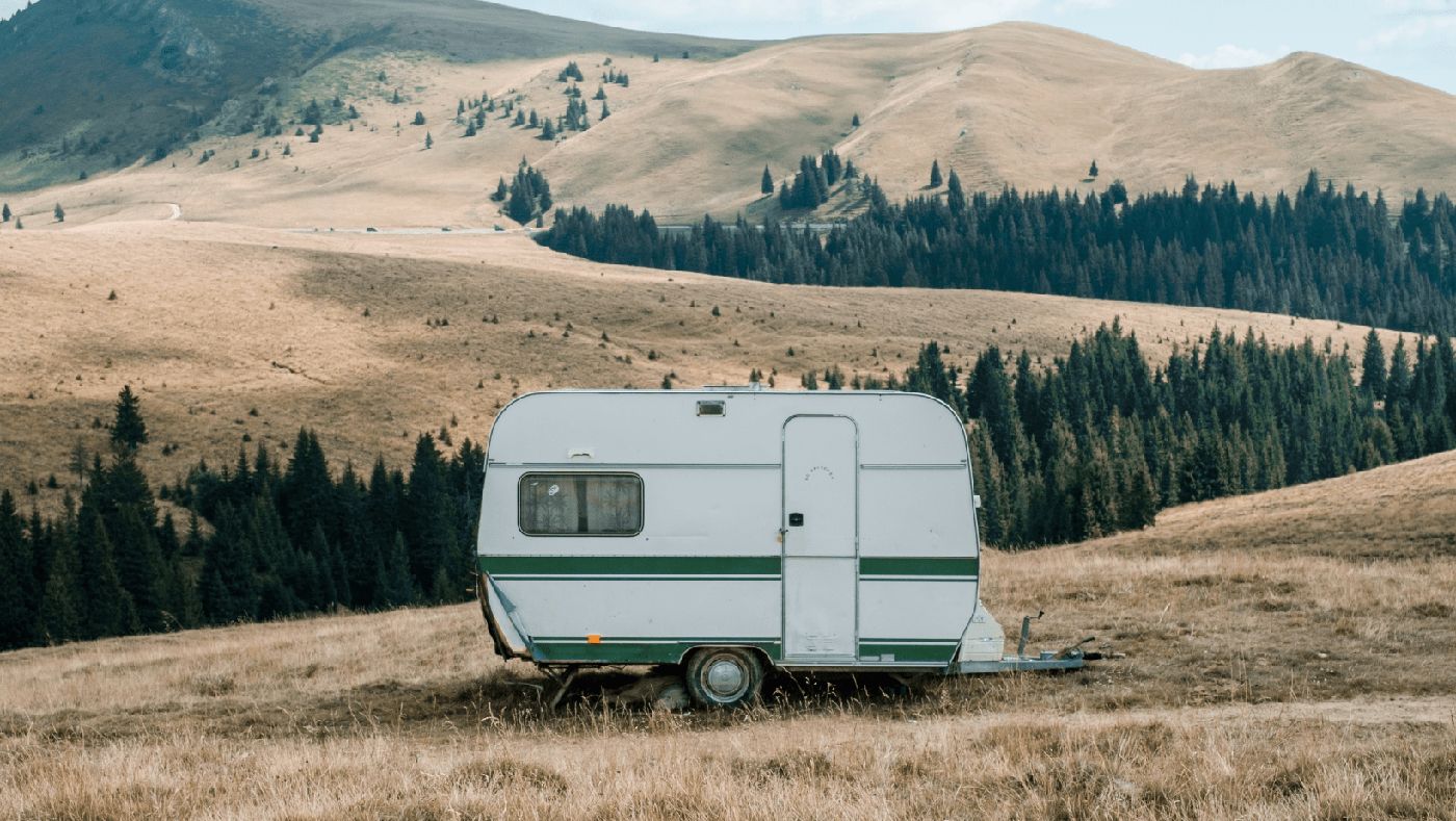 Caravana estacionada en plena montaña, perfecta para disfrutar de la naturaleza.
