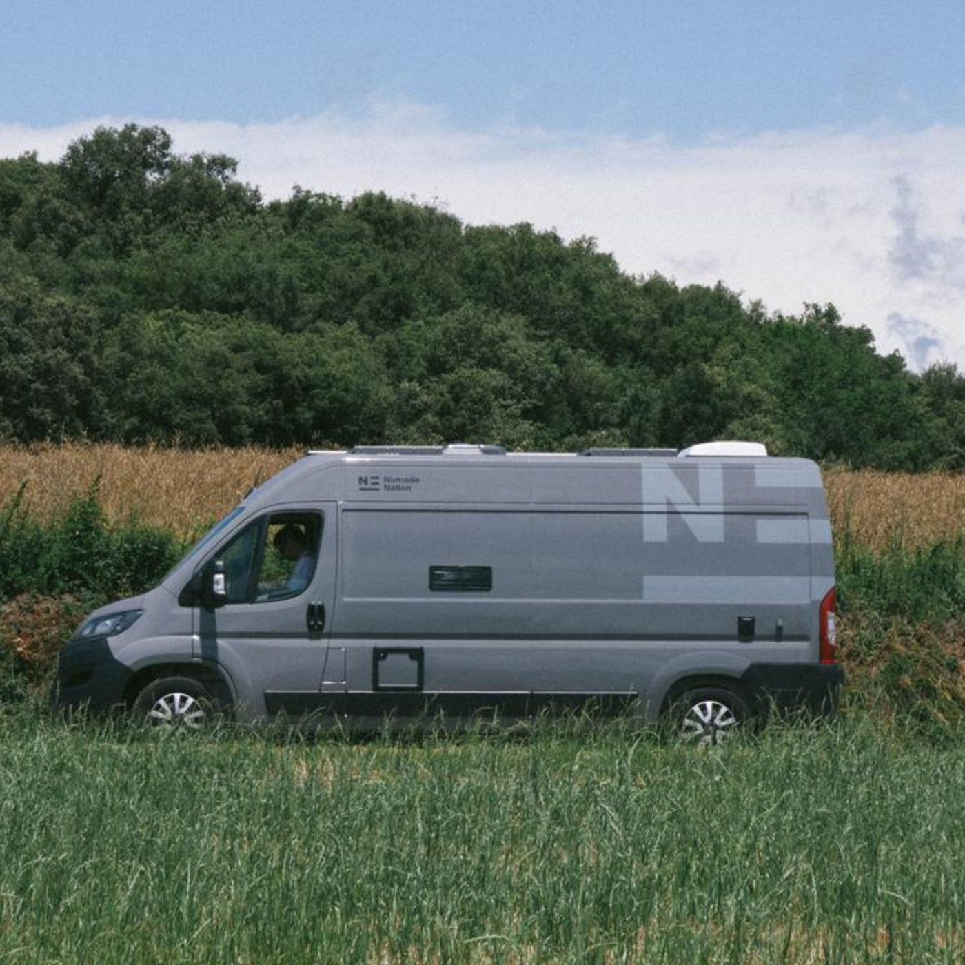 Camper Neo de Nomade Nation estacionada en plena naturaleza, ejemplo de ecoturismo sostenible.