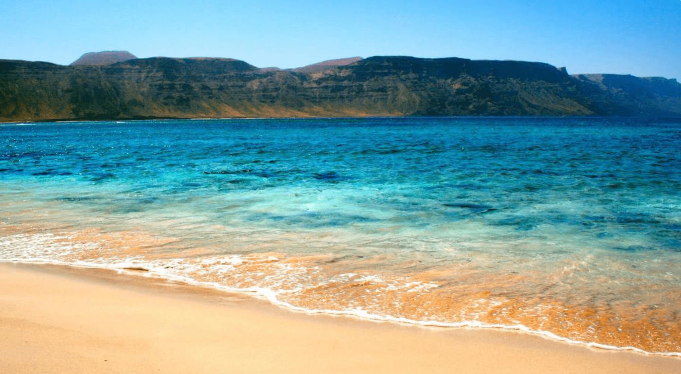 Playa de la Francesa en Lanzarote, una joya natural en La Graciosa, perfecta para disfrutar de aguas cristalinas y paisajes volcánicos en tu ruta camper.