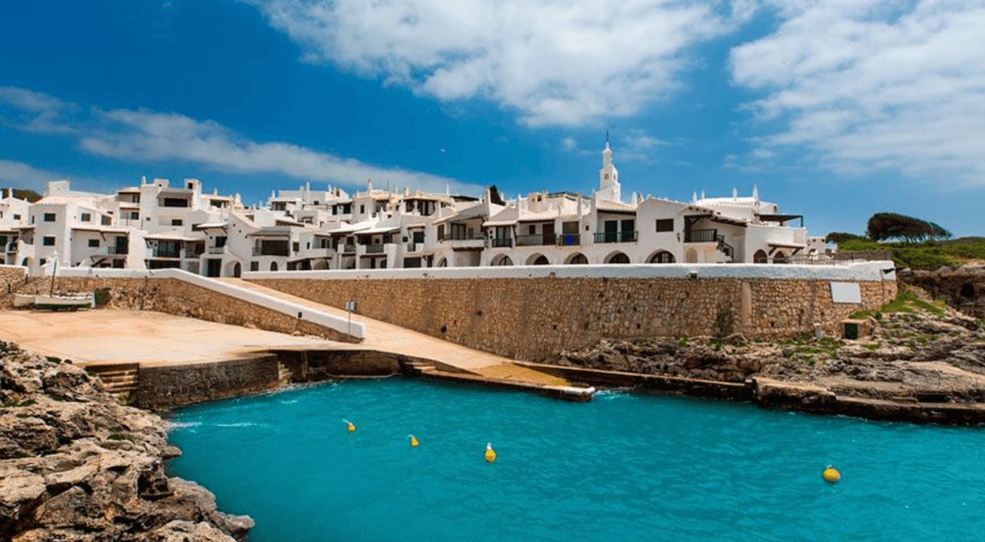 Las pintorescas calles de Binibeca, un encantador pueblo costero en Menorca, ideal para explorar en camper.