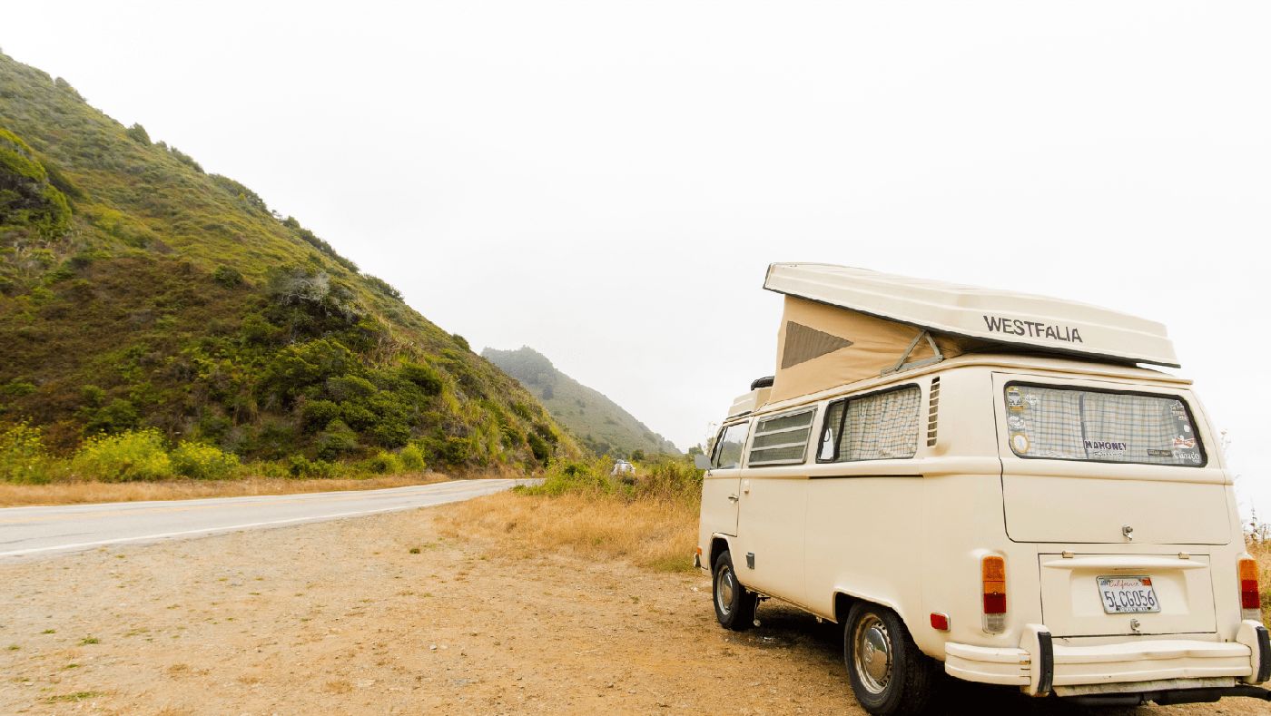 Furgo camper estacionada junto a una carretera secundaria, el punto perfecto para una pausa con vistas.