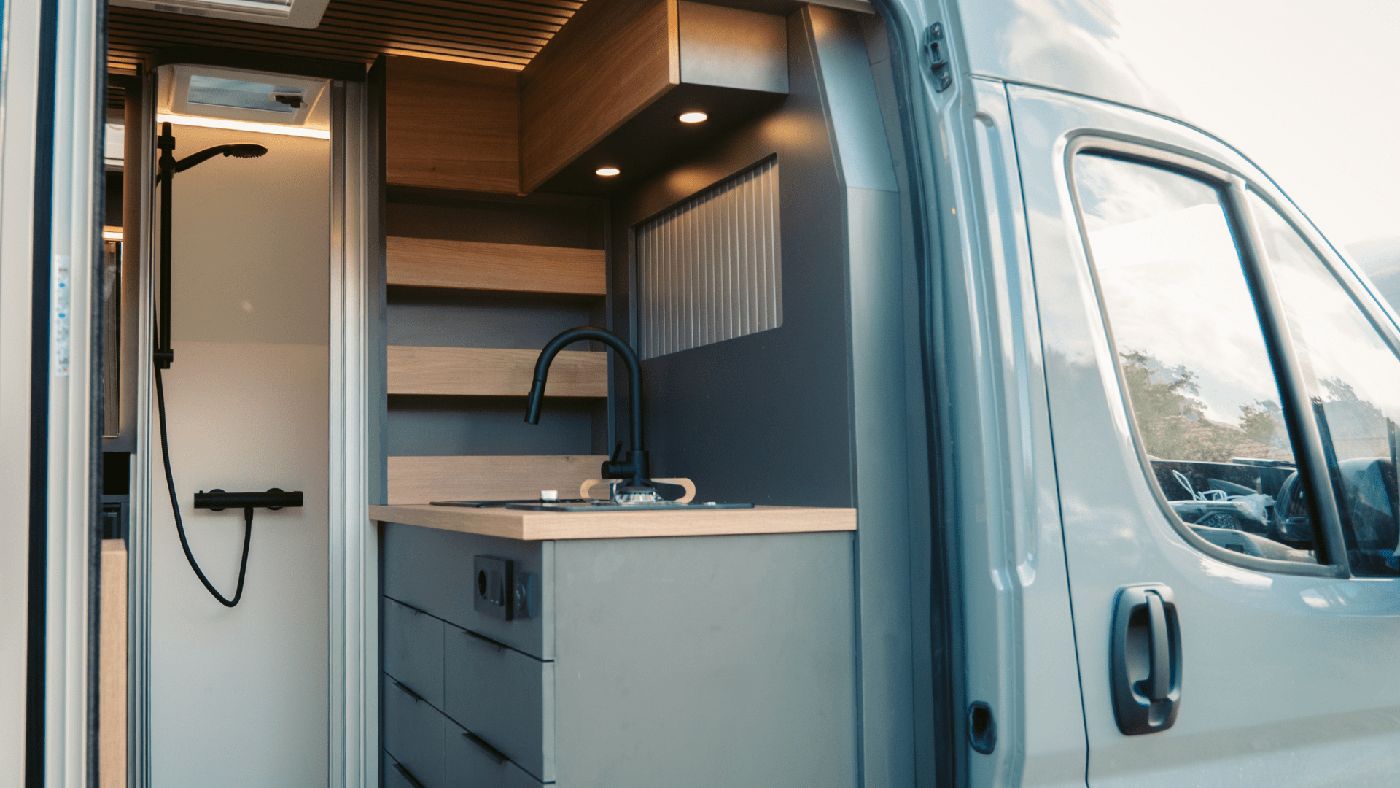 Interior del nuevo modelo Neo de Nomade Nation, mostrando las comodidades esenciales para un viaje en furgoneta camper.