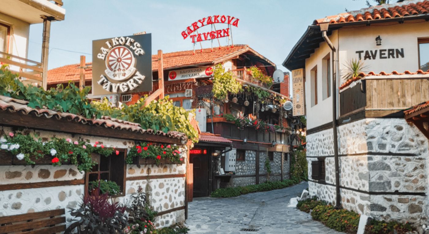 Calle empedrada en el centro de Bansko, Bulgaria, rodeada de casas tradicionales.