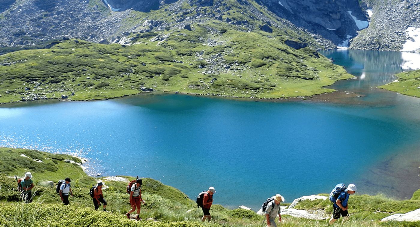Senderistas recorriendo la ruta de los 7 lagos de Rila, rodeados de montañas y paisajes naturales.