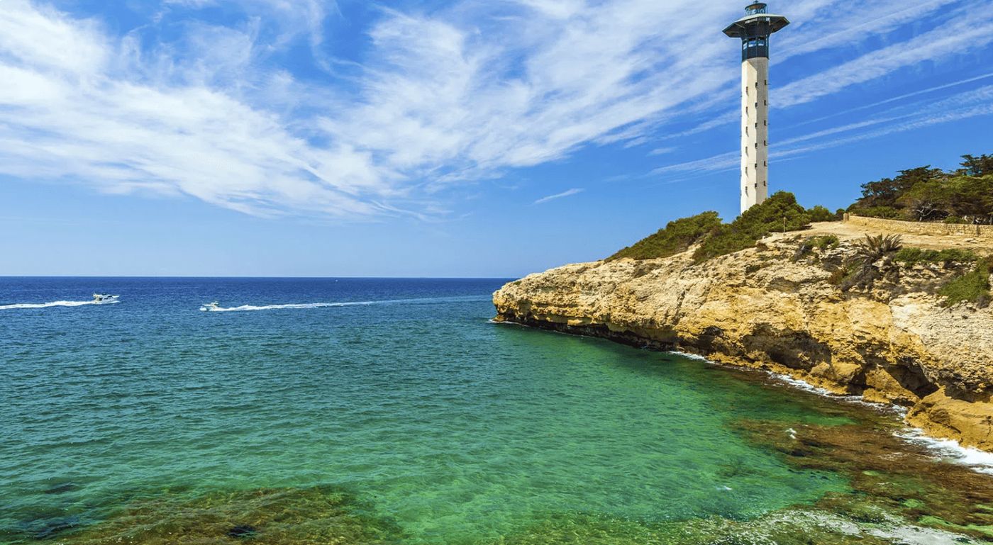 Vista de la playa y el faro de Torredembarra, un destino imprescindible en la Costa Daurada.