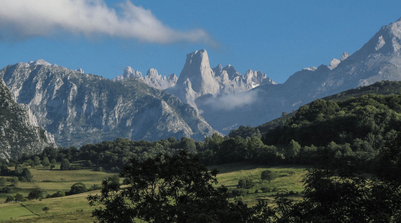 Panorámica de los imponentes Picos de Europa, con el Naranjo de Bulnes destacando en el paisaje, ideal para tu ruta en furgoneta camper.