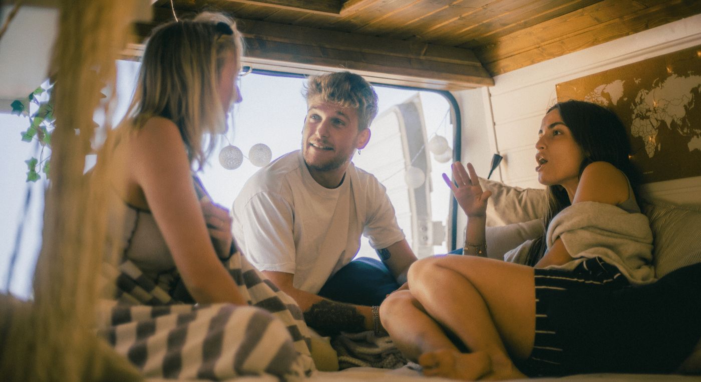 Tres jóvenes disfrutando de la experiencia del van life en el interior de una camper.