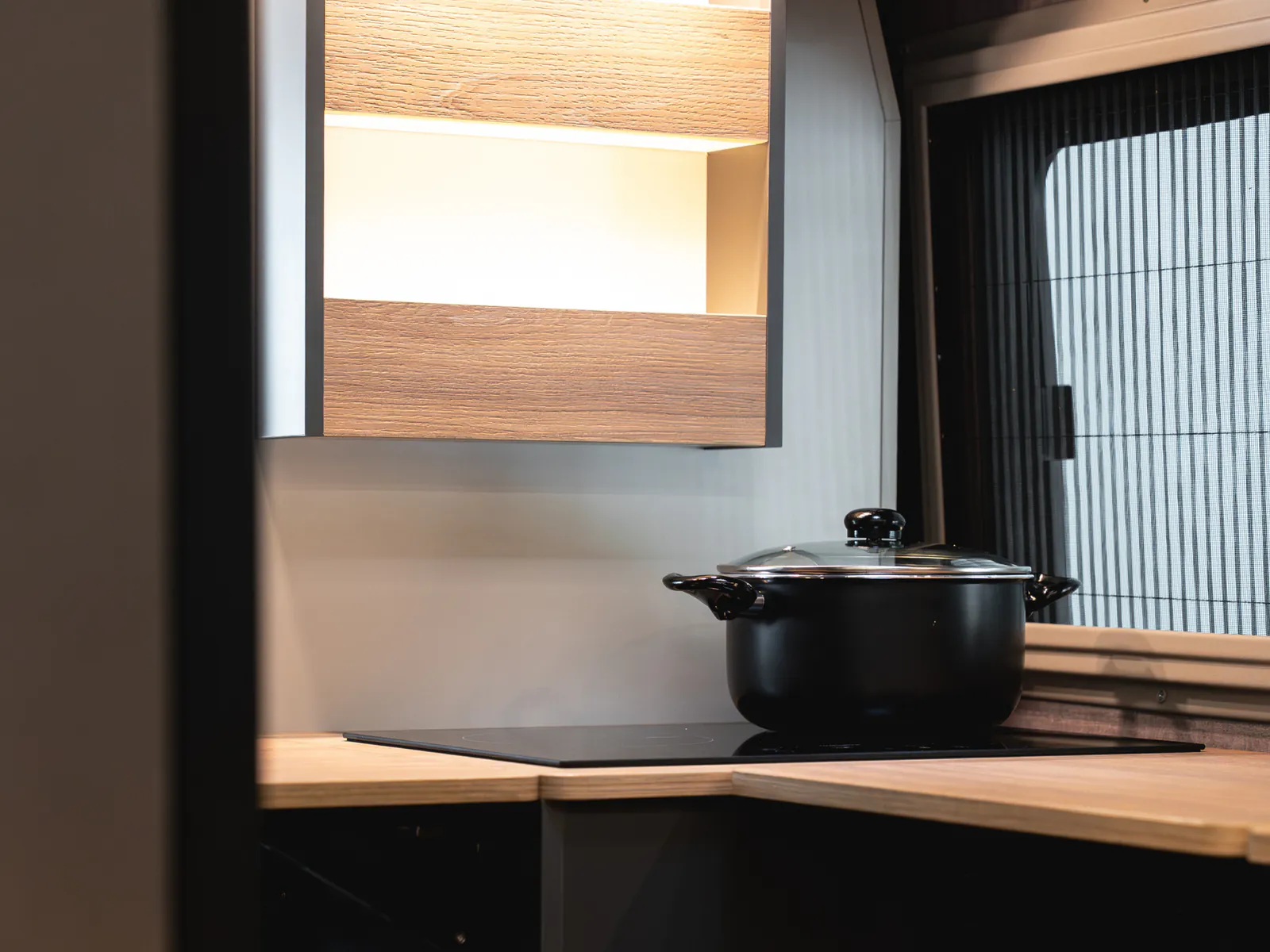 The Neo S kitchen, with the induction hob and the wooden worktop beside the window