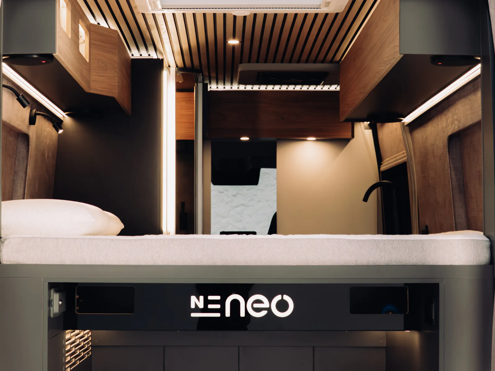 The bedroom seen from the rear doors, with the lit garage front beneath the bed