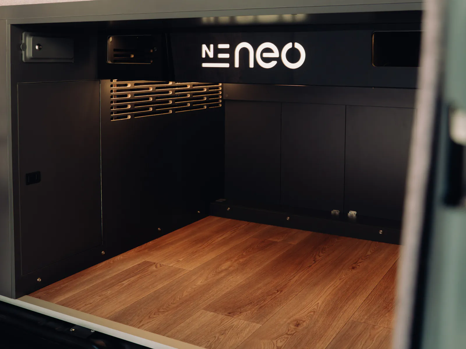 The fixed garage under the bed, with a wooden floor and access from the rear doors