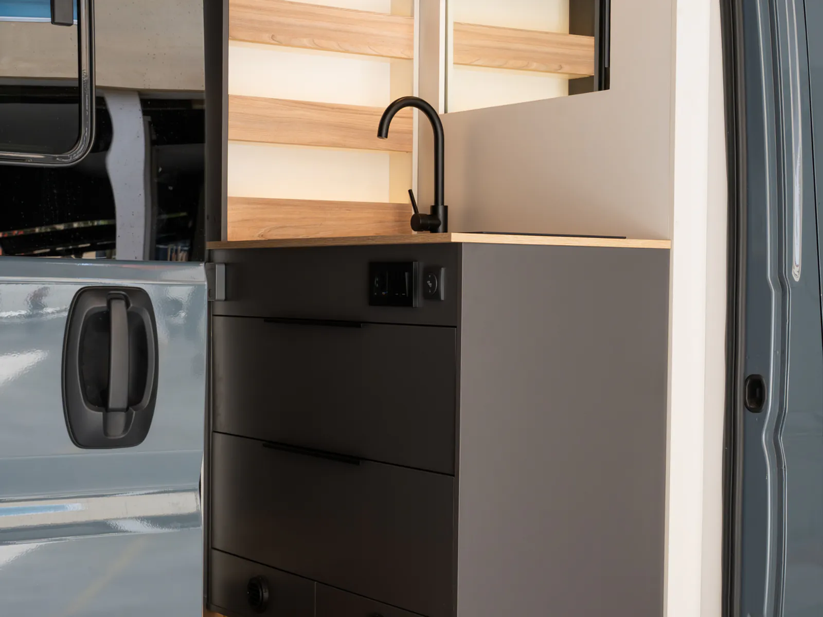 The kitchen unit with sink and drawers, with the sliding door open