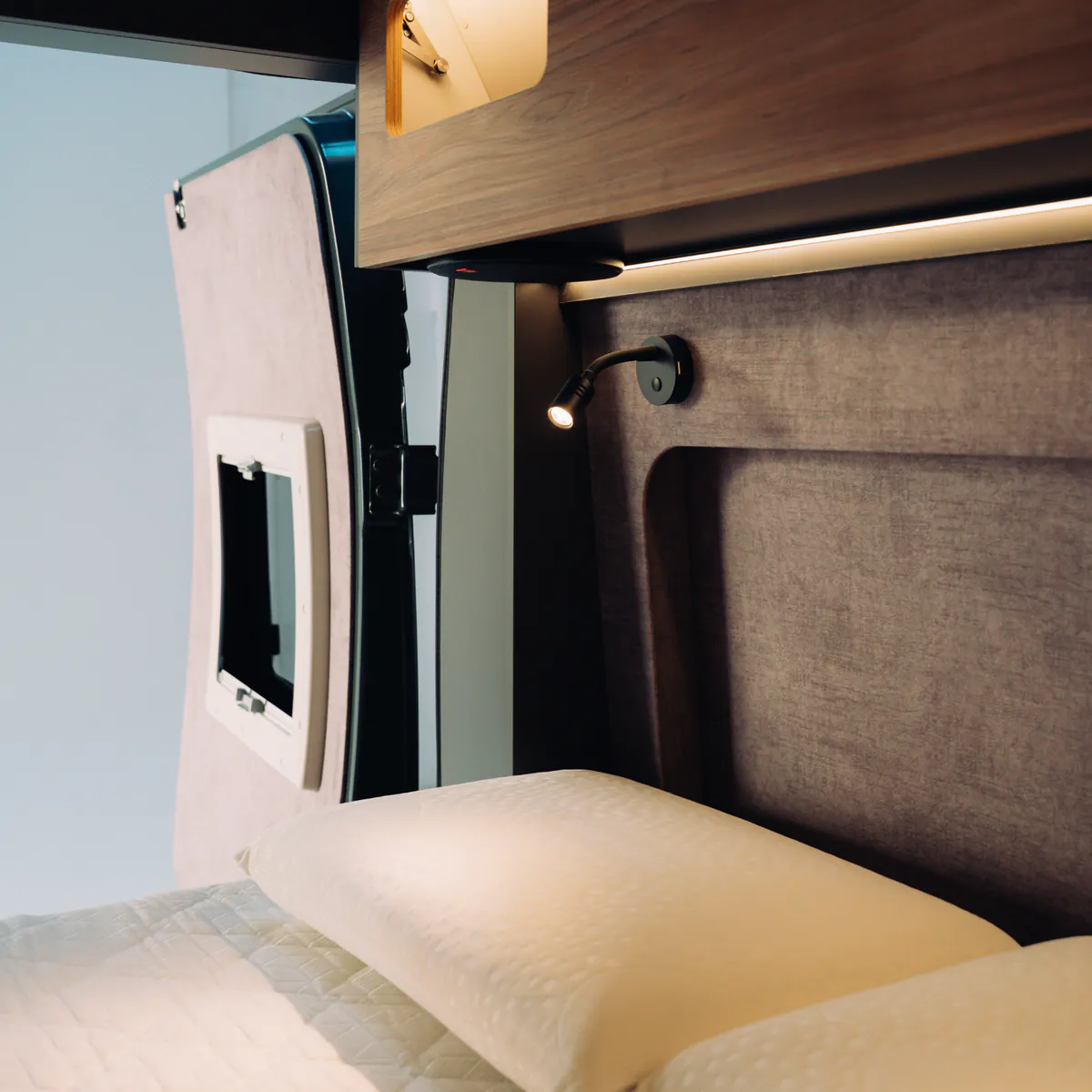The bedroom's textile panelling, with a reading light and a wooden shelf