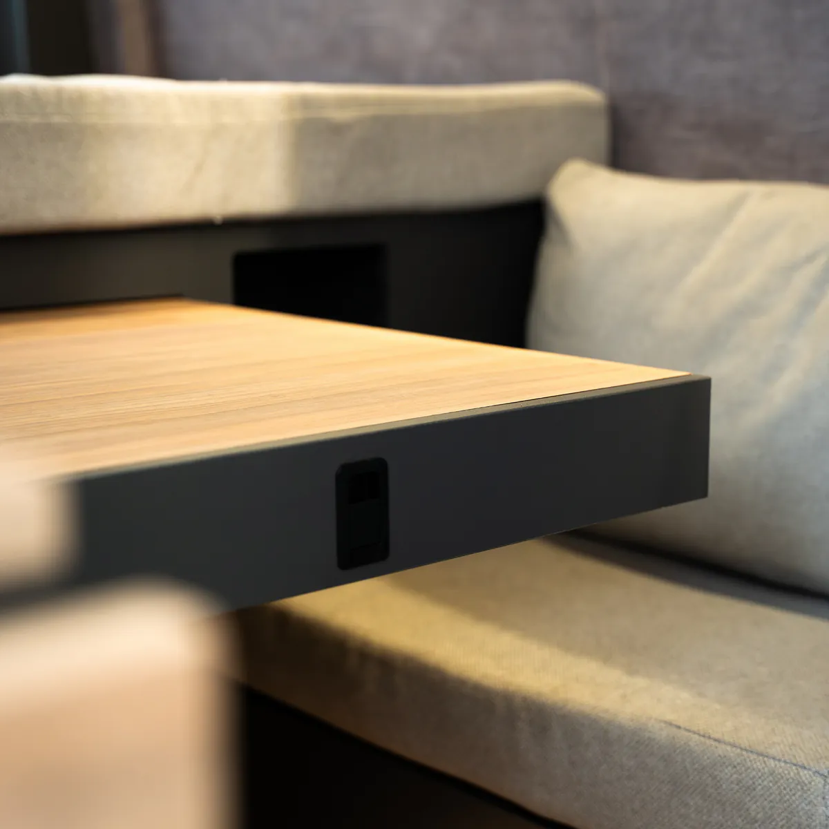 The natural wood table over the upholstered sofa