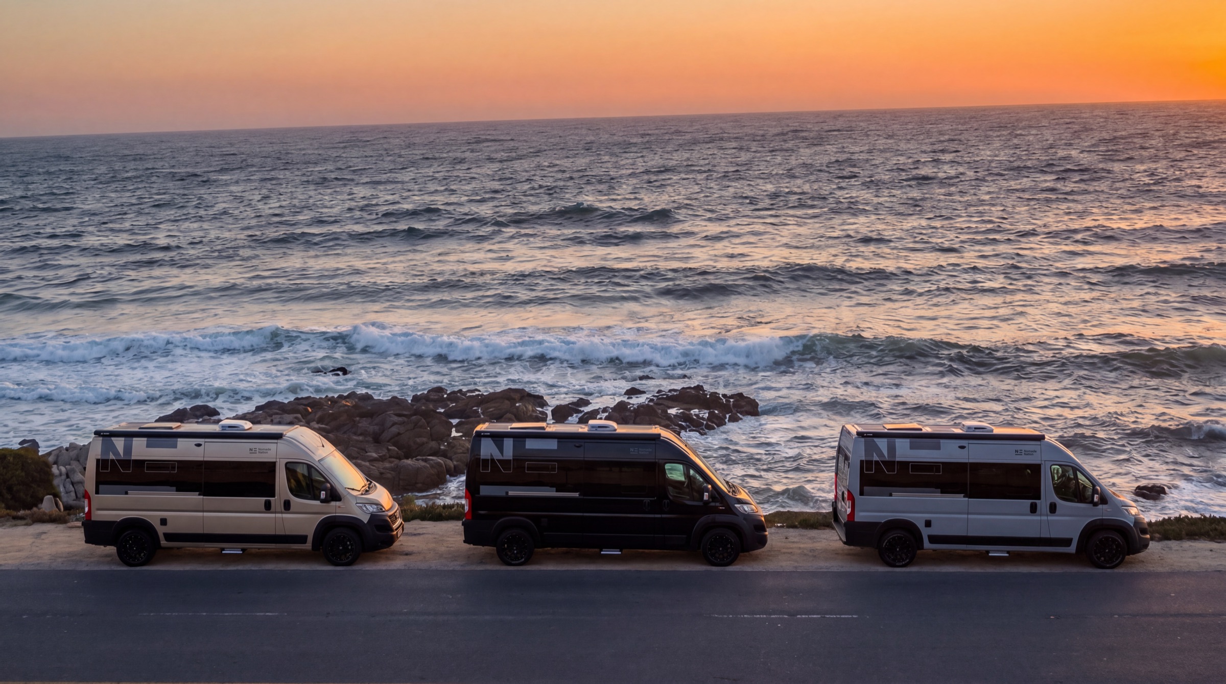 Three Nomade campers by the sea at sunset